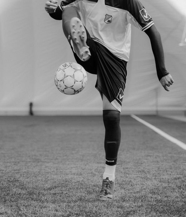 Man performing a core strength exercise in a dark room with icy light.